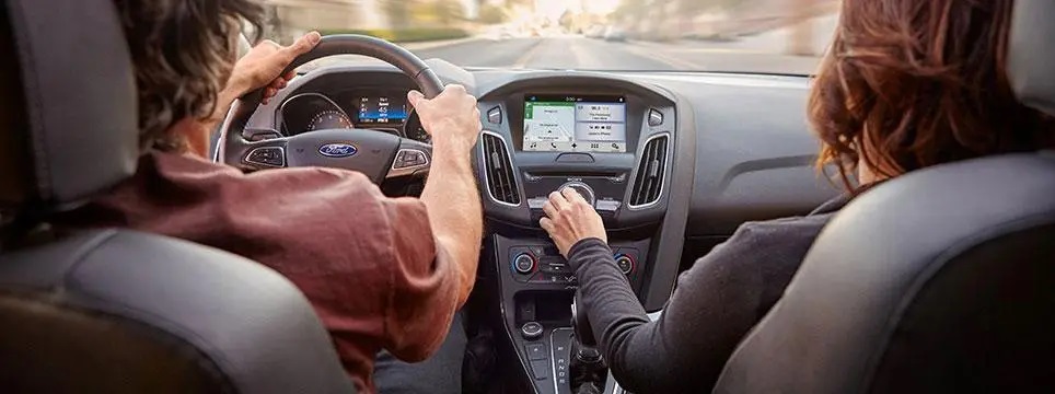 Driving in a modern car with touchscreen navigation and dashboard controls.